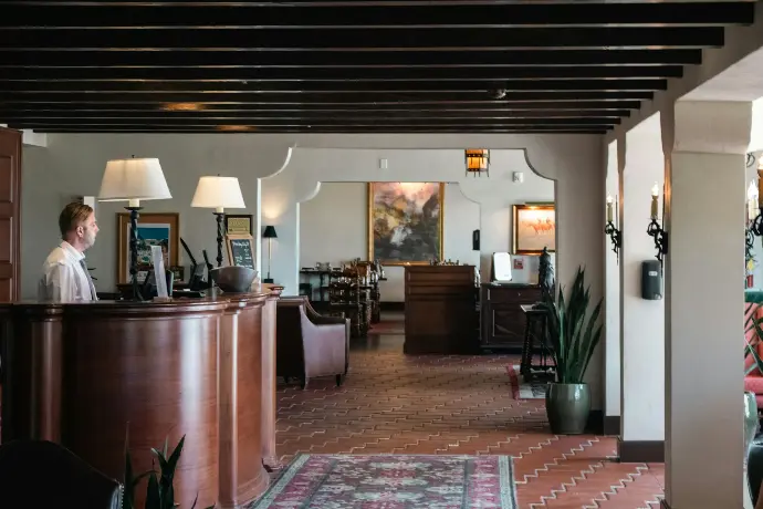 A woman is standing at the front desk of a restaurant